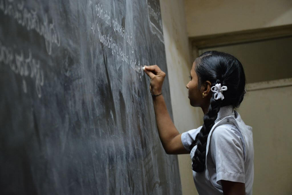 Indian Student writing in blackboard