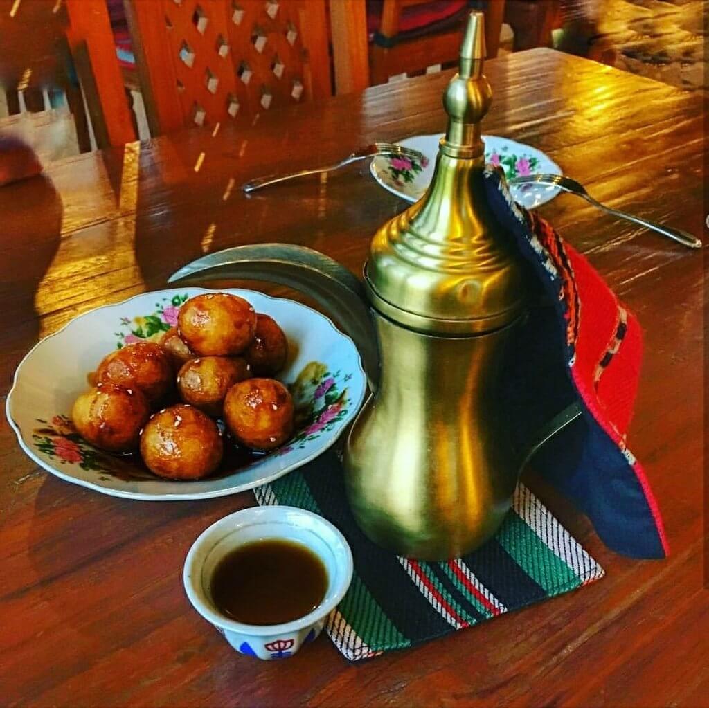 an image of luqaimat with arabic coffee and dates
