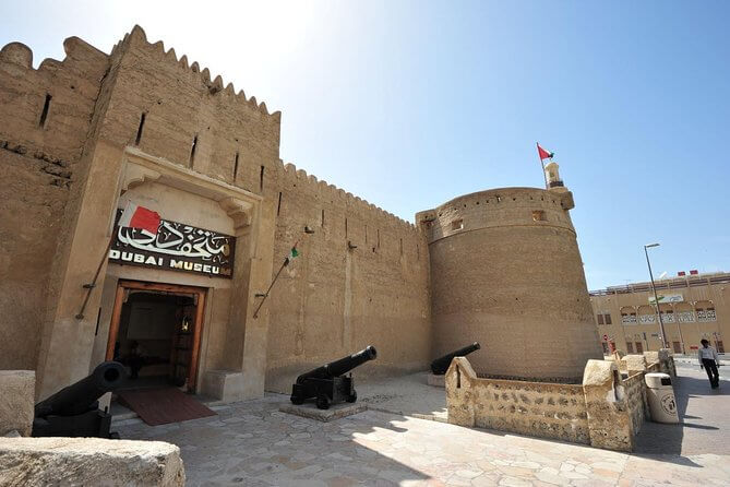 one of the Dubai's cultural and heritage sites which is Dubai fort looks like an ancient or coral, mud building with some canons outside of main entrance
.