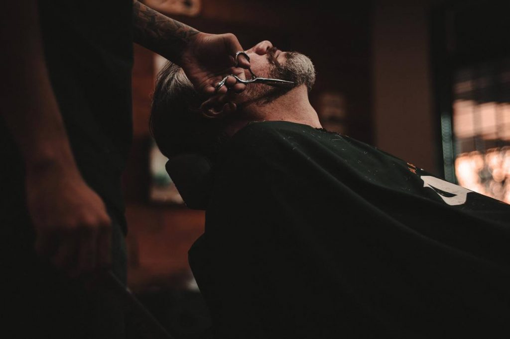 grooming business , a man getting a haircut.