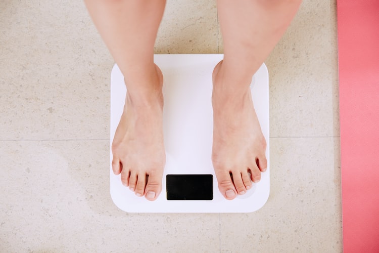 person standing on white digital weighing scale.