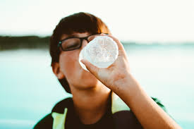 a boy drinking water from a bottle