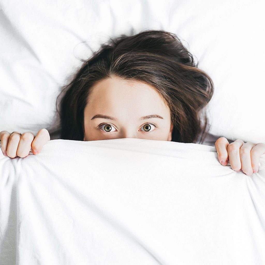 girl looking from bed wide open eyes