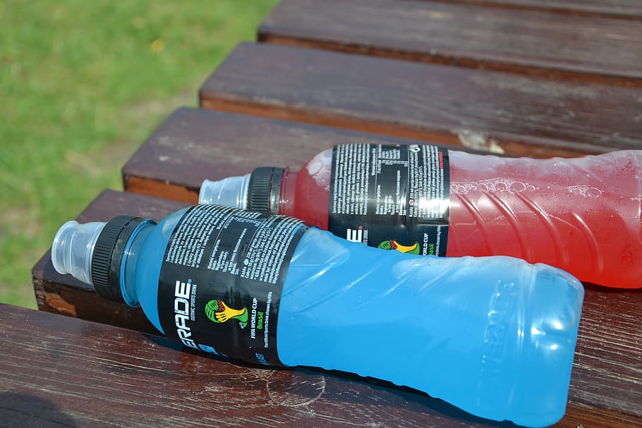 two bottles of sports drinks over a bench